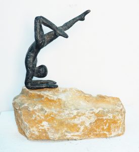 Bronzefigur Wettkampf stützt sich auf einen Naturstein